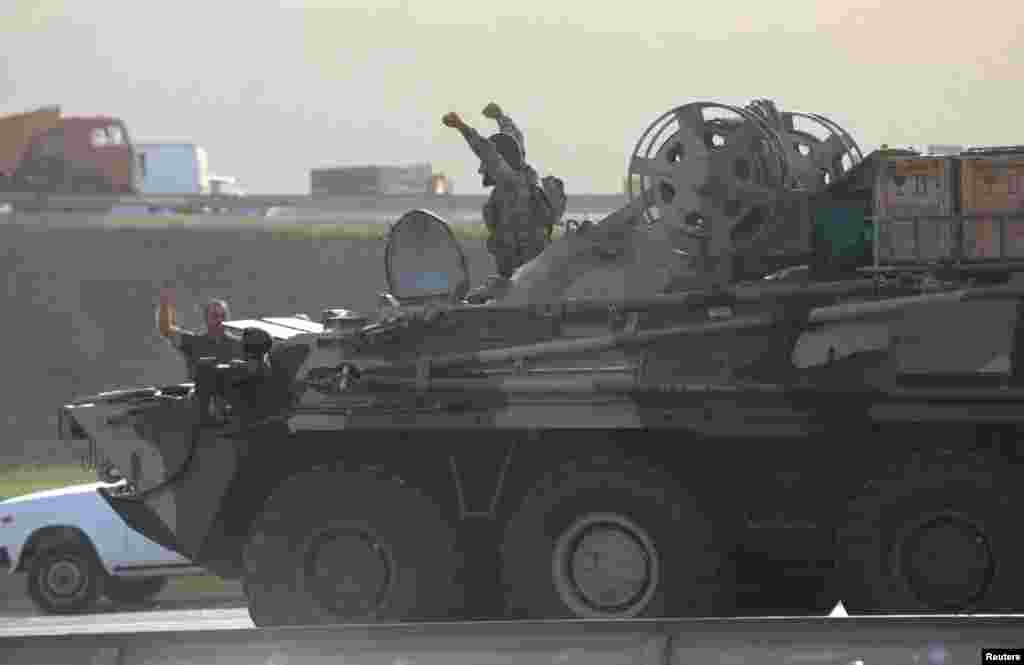 Raising their arms to signal victory, Azerbaijani soldiers ride in an armored personnel carrier in Baku, the Azerbaijani capital.