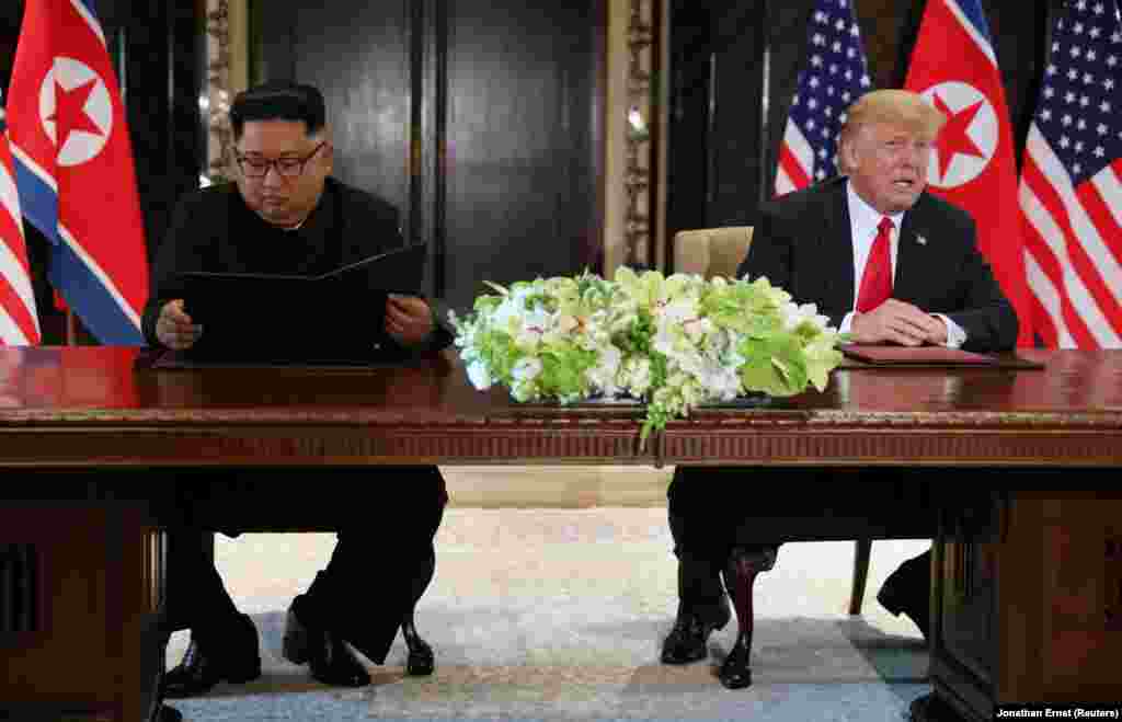 Дональд Трамп комментирует подписание документа в то время, как Ким Чен Ын рассматривает только что подписанный документ. "Сегодня у нас прошла историческая встреча, мы решили оставить прошлое позади. Мы решили подписать исторический документ – заявил северокорейский лидер Ким Чен Ын. – Мир увидит большое изменение". 