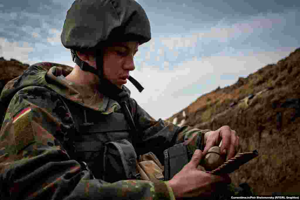 Украинский боец "Азова" перезаряжает оружие. Село Широкино в Донецкой области, 18 апреля 2015