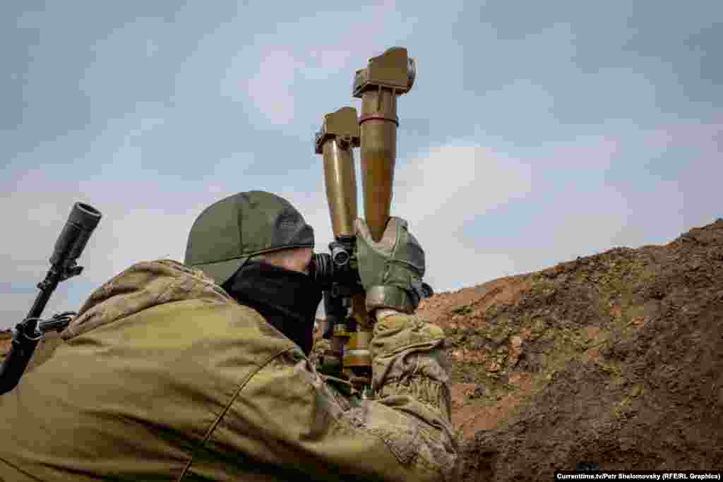Боец "Азова" смотрит на вражеские позиции. Село Широкино в Донецкой области. 18 апреля 2015 