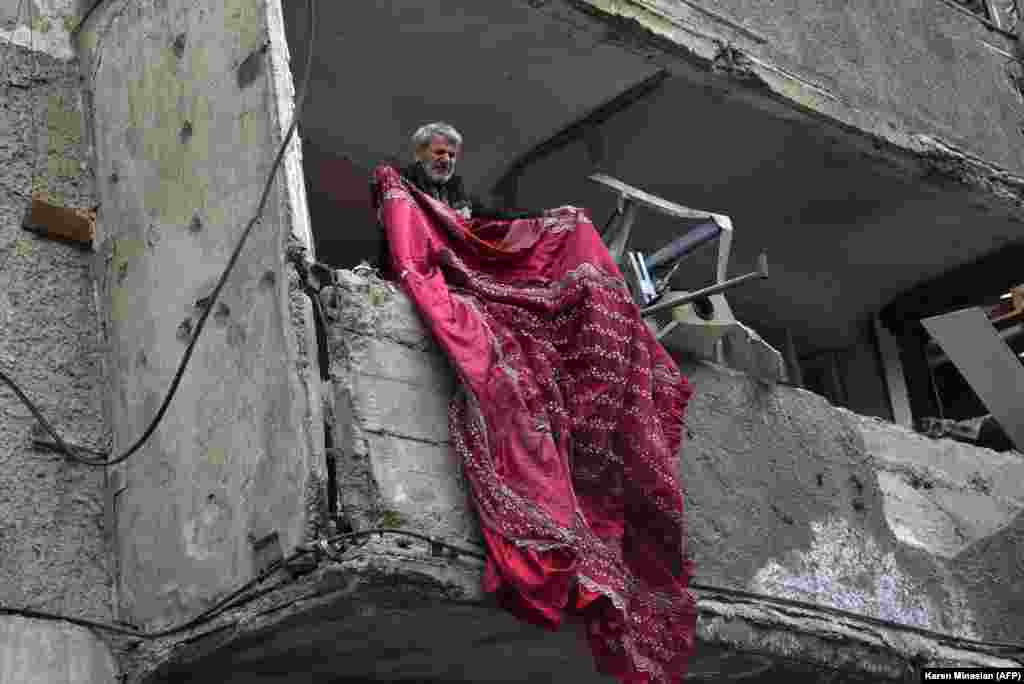 NAGORNO-KARABAKH -- Hrach Vanian, 75, removes debris in his apartment damaged by shelling during the ongoing military conflict between Armenia and Azerbaijan over the breakaway region of Nagorno-Karabakh, in the disputed province's capital of Stepanakert,
