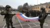 Russian servicemen fold their national flag during a January 13, 2022 ceremony in Almaty marking the beginning of the withdrawal of Collective Security Treaty Organization (CSTO) peacekeeping troops from Kazakhstan.
