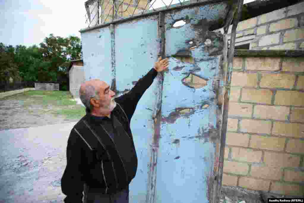 A resident of the Azerbaijani town of Tartar, roughly 52 kilometers north of Nagorno-Karabakh, shows holes in his house’s gates, damaged by shelling.