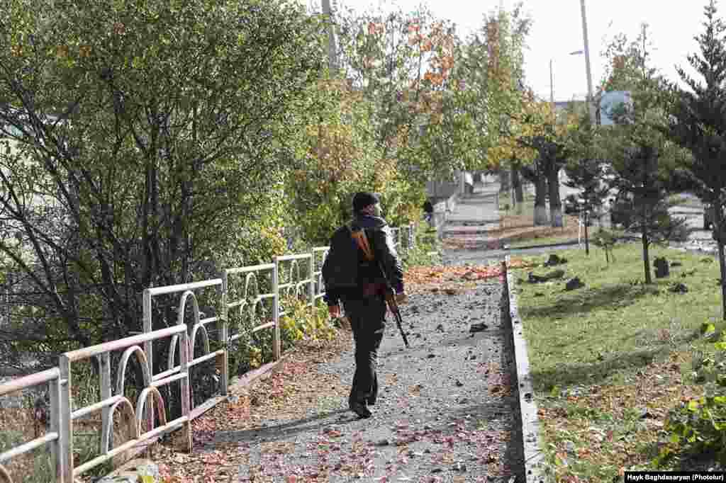 An armed man walks along a street in Shushi (Shusha) a few days before de facto Nagorno-Karabakh leader Arayik Harutiunian announced on October 29, 2020 that Azerbaijani forces were 5 kilometers away from the town. 