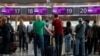 Passengers wait to check in for the last Belavia flight from Kyiv's Boryspil International Airport to Minsk on May 25, 2021. 
