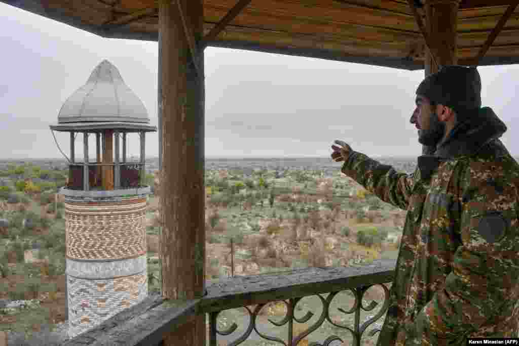 An Armenian man points toward a minaret at Agdam&#39;s 19th-century Juma mosque on November 19, 2020. The building, also known as the Agdam mosque, survived the 1992-1994 Karabakh war, but was abandoned during ethnic Armenians&#39; occupation of the town. On November 20, 2020, Azerbaijanis attended Friday prayers in the sanctuary.&nbsp;
